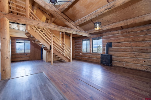 interior space featuring stairs, plenty of natural light, wood finished floors, and a wood stove