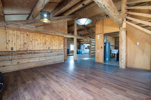 interior space featuring beam ceiling, water heater, rustic walls, and wood finished floors