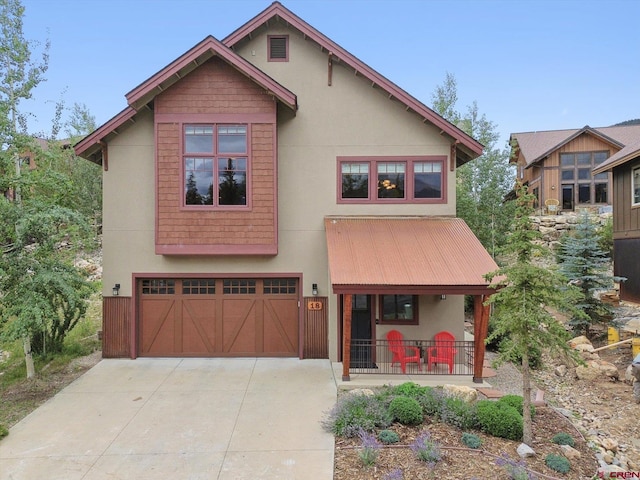 view of front of property with an attached garage, a porch, concrete driveway, and stucco siding