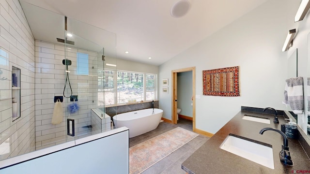 bathroom with vaulted ceiling, a sink, a shower stall, and a freestanding bath