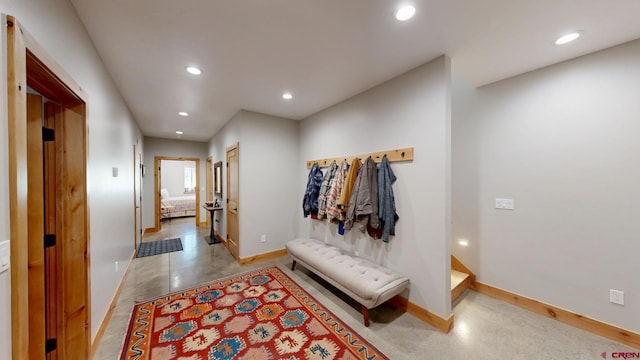 hallway with recessed lighting and baseboards