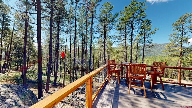 wooden terrace featuring a forest view