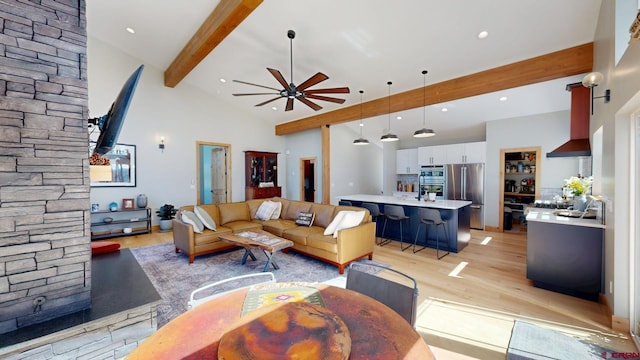 living room featuring a ceiling fan, beamed ceiling, light wood-type flooring, high vaulted ceiling, and recessed lighting