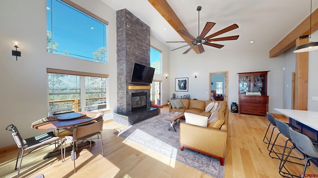 living room with beam ceiling, a fireplace, recessed lighting, light wood-style floors, and ceiling fan