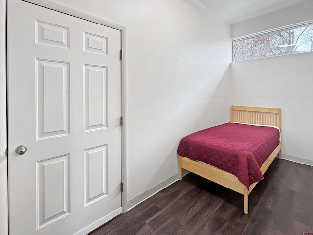 bedroom with wood finished floors and baseboards