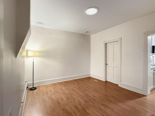 unfurnished bedroom featuring baseboards, visible vents, and wood finished floors