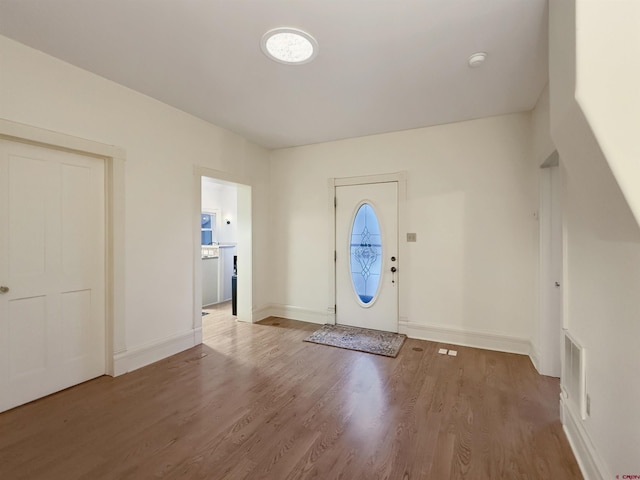 foyer with baseboards and wood finished floors