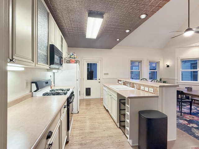 kitchen featuring black appliances, a sink, light countertops, and a ceiling fan