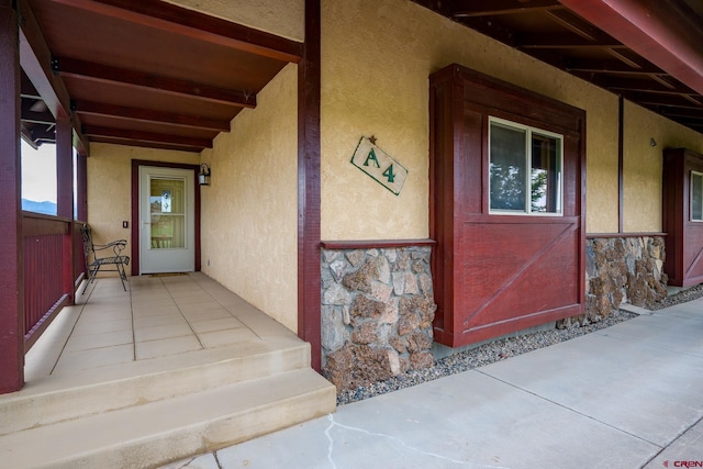 entrance to property with stone siding and stucco siding