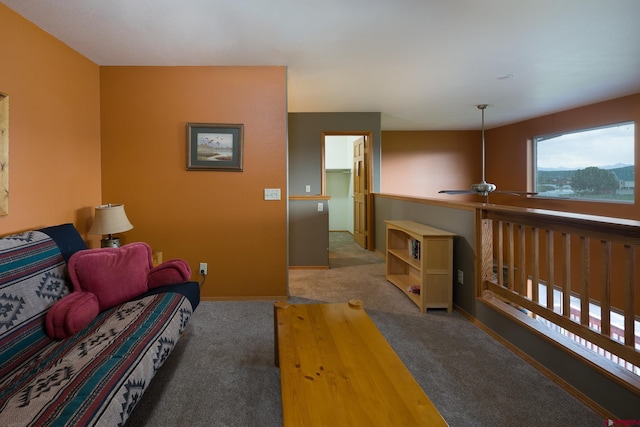 carpeted living area featuring a ceiling fan and baseboards