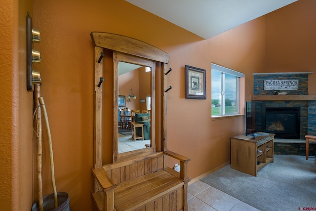 hall with carpet floors, baseboards, and tile patterned floors