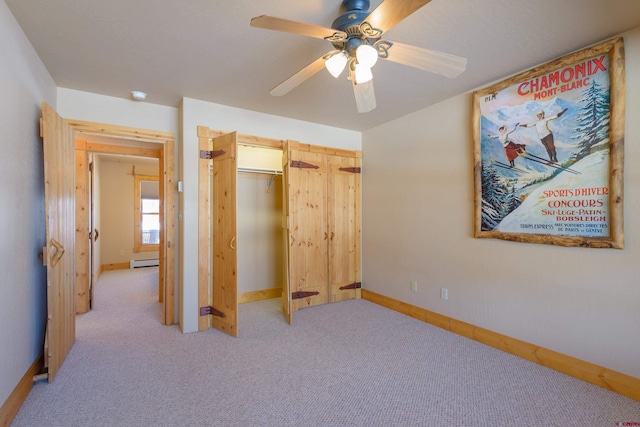 bedroom featuring ceiling fan, light carpet, baseboards, baseboard heating, and a closet