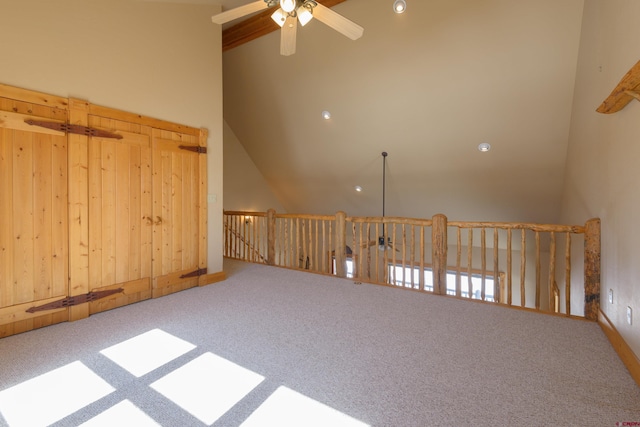 spare room with ceiling fan, carpet floors, and a towering ceiling