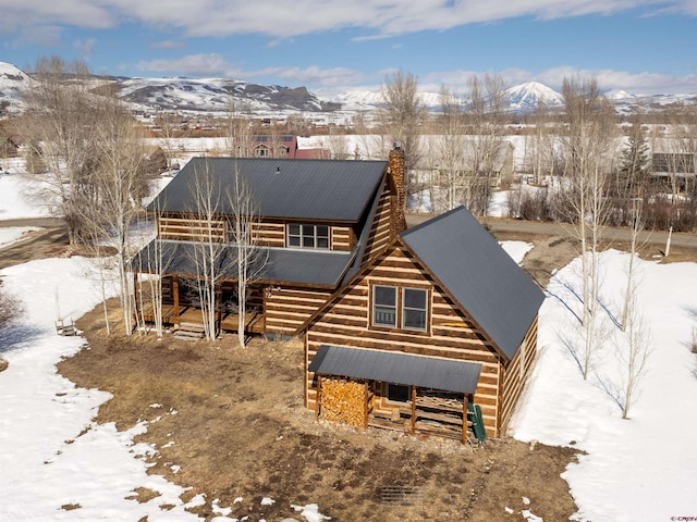 view of front of house with metal roof, a chimney, and a mountain view