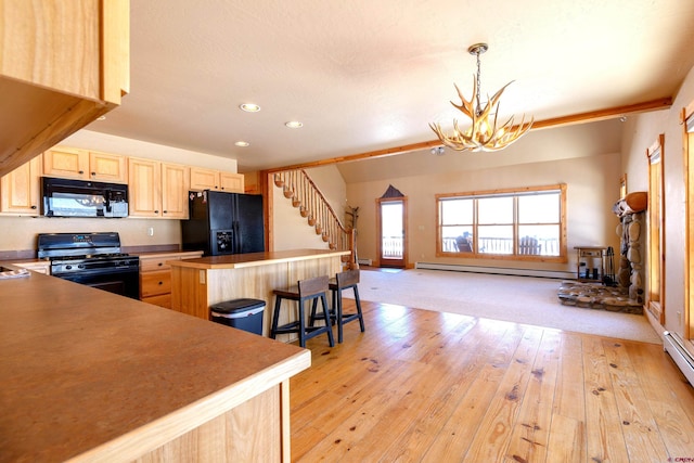 kitchen featuring a center island, a notable chandelier, baseboard heating, light brown cabinetry, and black appliances