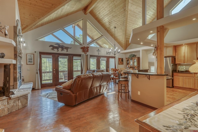 living area with french doors, light wood-type flooring, wood ceiling, and an inviting chandelier