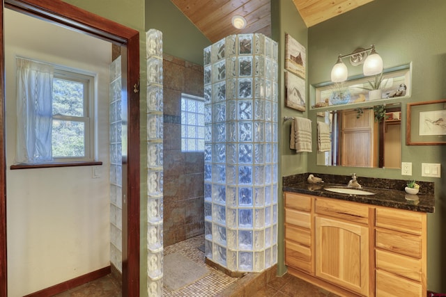 bathroom featuring a walk in shower, lofted ceiling, tile patterned flooring, vanity, and baseboards