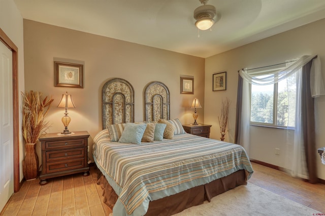 bedroom with light wood-type flooring, baseboards, and a ceiling fan