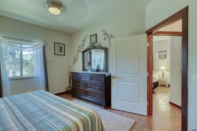 bedroom with baseboards, ceiling fan, and light wood finished floors