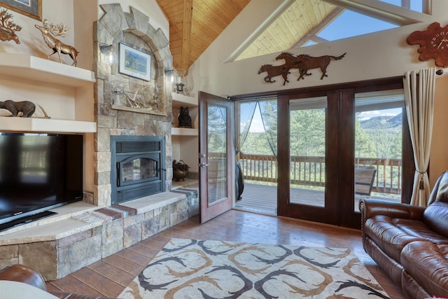 unfurnished living room with high vaulted ceiling, wooden ceiling, a fireplace, and wood finished floors