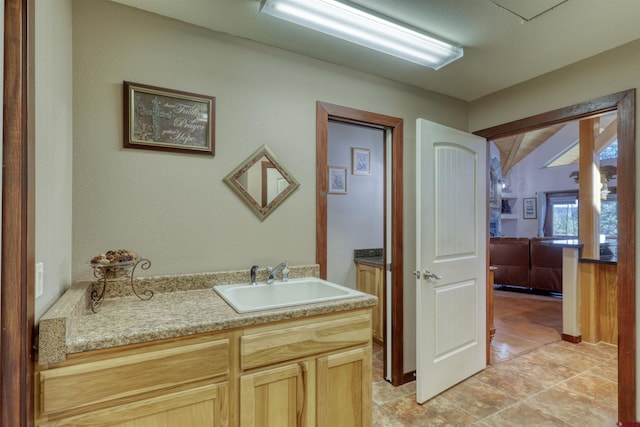 bathroom with vaulted ceiling and vanity