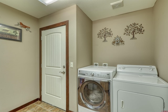 clothes washing area featuring laundry area, visible vents, washer and clothes dryer, and baseboards