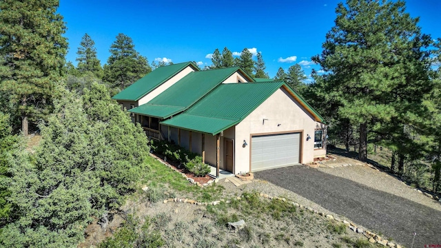 exterior space with metal roof, gravel driveway, and stucco siding