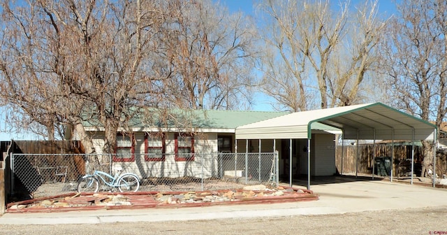 ranch-style house featuring a detached carport, concrete driveway, and fence