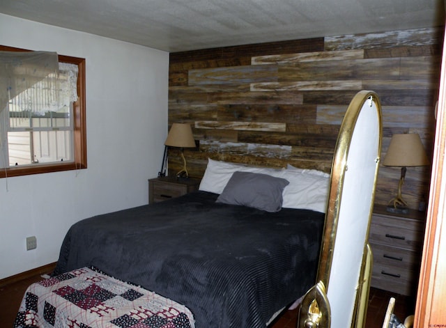 bedroom featuring baseboards and wood walls