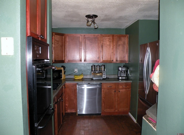 kitchen with brown cabinetry, a textured ceiling, stainless steel appliances, and dark countertops