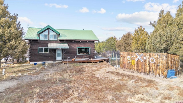 log-style house with a deck, metal roof, and log exterior