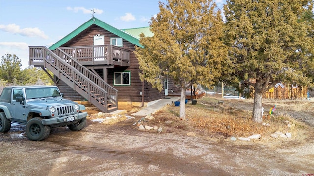 view of front of house featuring a deck, stairs, and metal roof