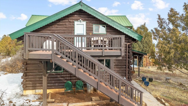 back of property with stairs, metal roof, a wooden deck, and log siding