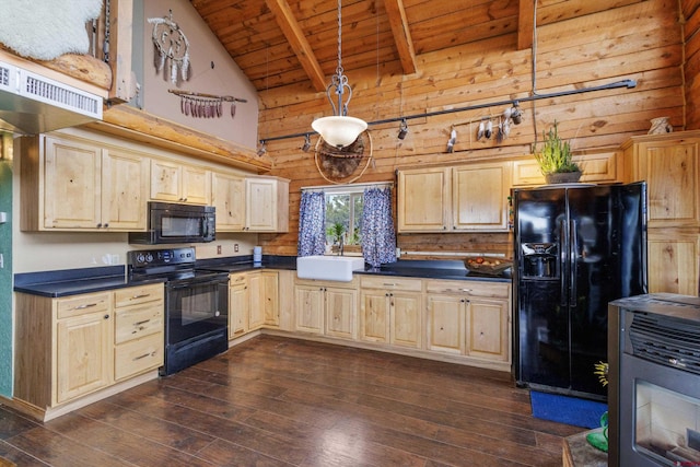 kitchen with light brown cabinets, black appliances, dark countertops, and a sink