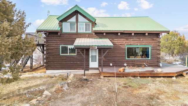 log home featuring a deck, metal roof, and log siding