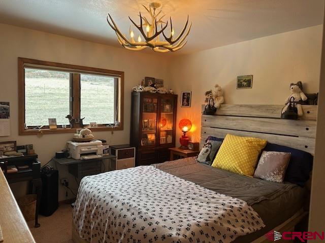 carpeted bedroom featuring a notable chandelier