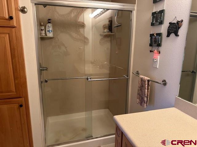 full bath featuring a stall shower and vanity