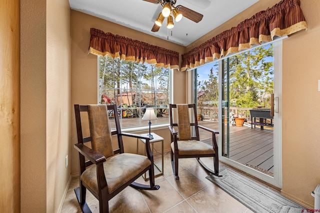 sitting room with ceiling fan and tile patterned flooring