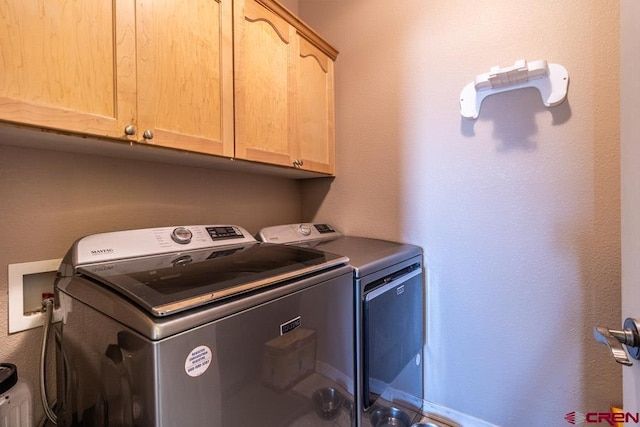 laundry area featuring washing machine and clothes dryer and cabinet space