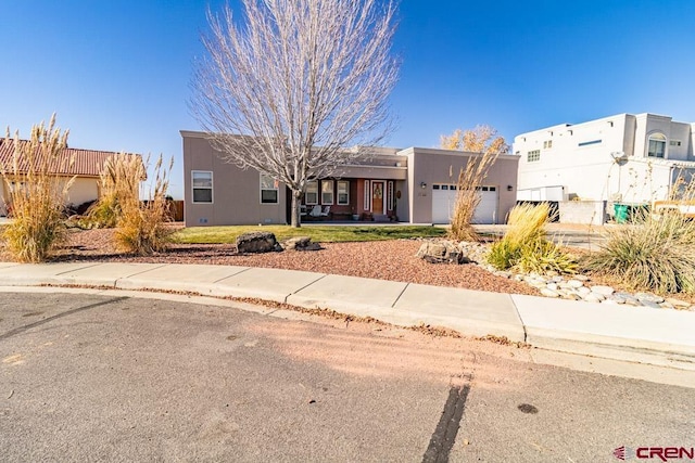 adobe home with an attached garage and stucco siding