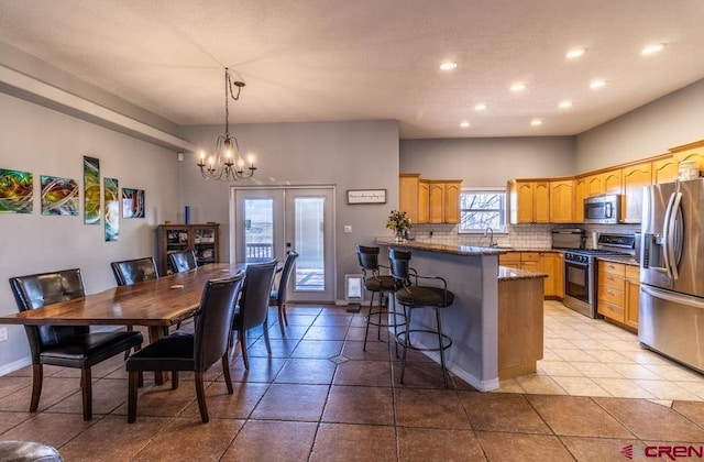 dining room with light tile patterned floors, baseboards, french doors, a chandelier, and recessed lighting