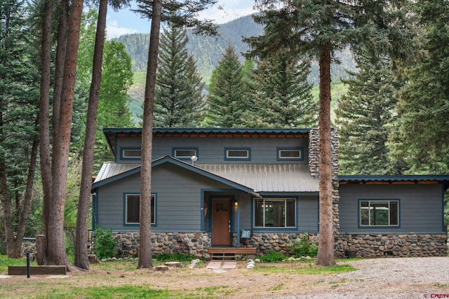 view of front of property featuring metal roof and stone siding