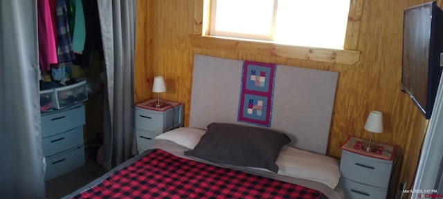 bedroom featuring wooden walls