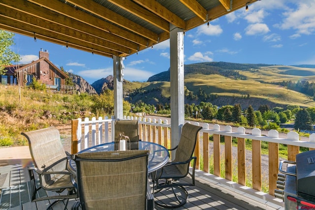 deck featuring a mountain view and outdoor dining space