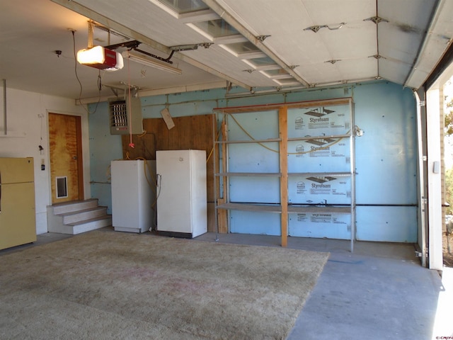 garage featuring a garage door opener, freestanding refrigerator, and a heating unit