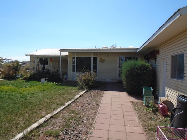 view of front of house featuring a front yard and metal roof