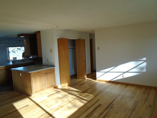 kitchen with light wood-style flooring and baseboards