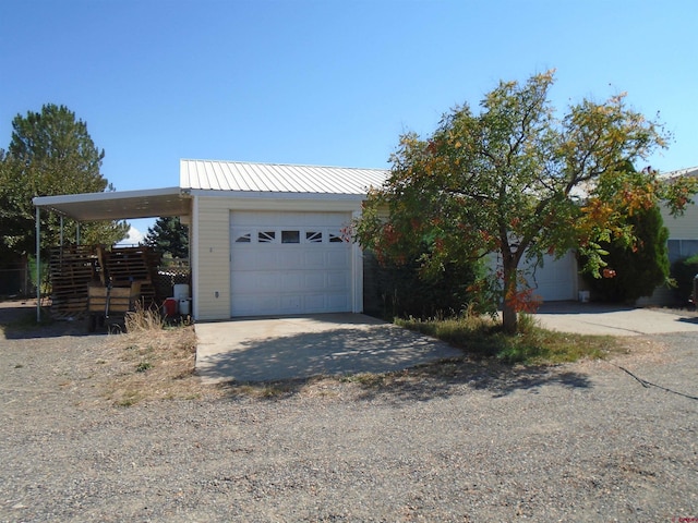 view of front of home with a detached garage and metal roof