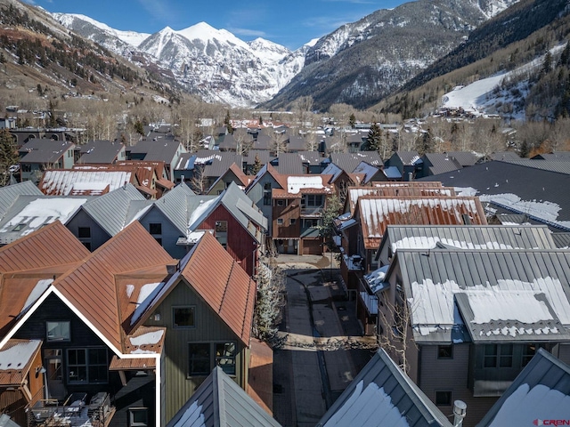 snowy aerial view with a residential view and a mountain view