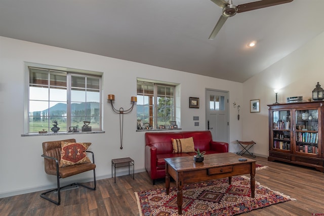 living area featuring baseboards, vaulted ceiling, and wood finished floors